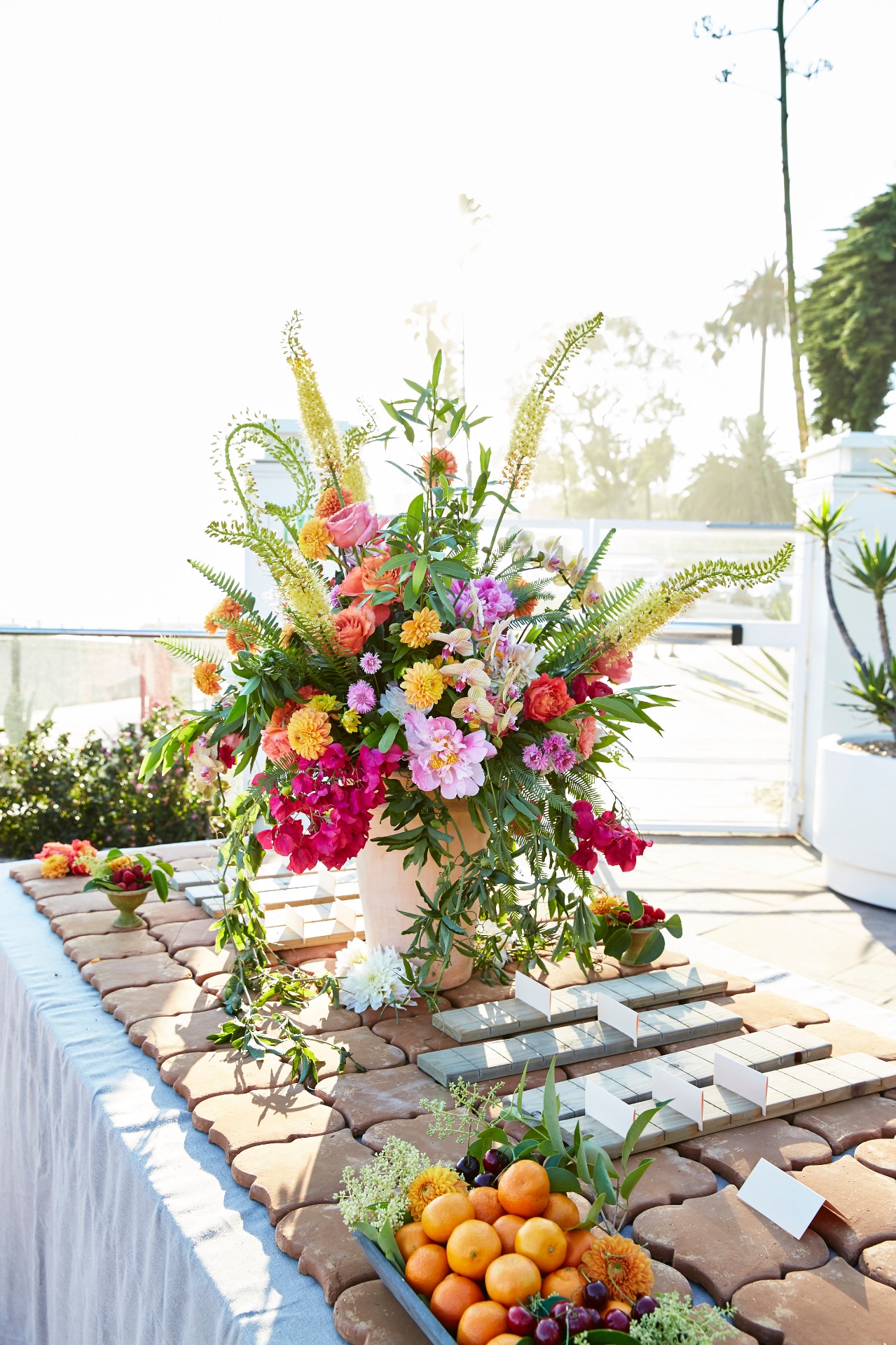 Bright floral centerpiece with citrus fruits on an outdoor terrace